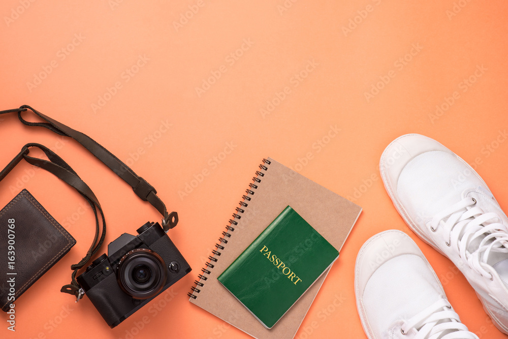 Summer traveling concept. Vacation accessories on orange background.