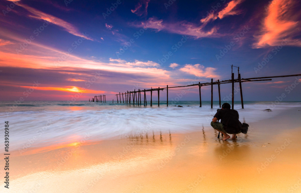 Evening light during sunset on the sea with an old wooden bridge.In Thailand.And popular with touris