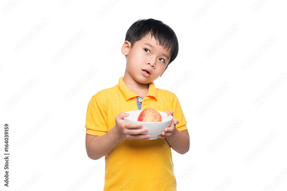 快乐的亚洲男孩拿着红苹果在碗里。