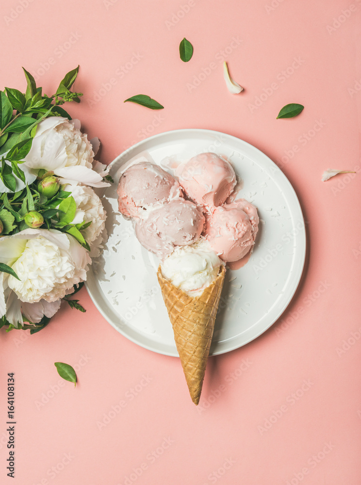 Flatlay of pastel pink strawberry and coconut ice cream scoops, sweet cones on white plate and white