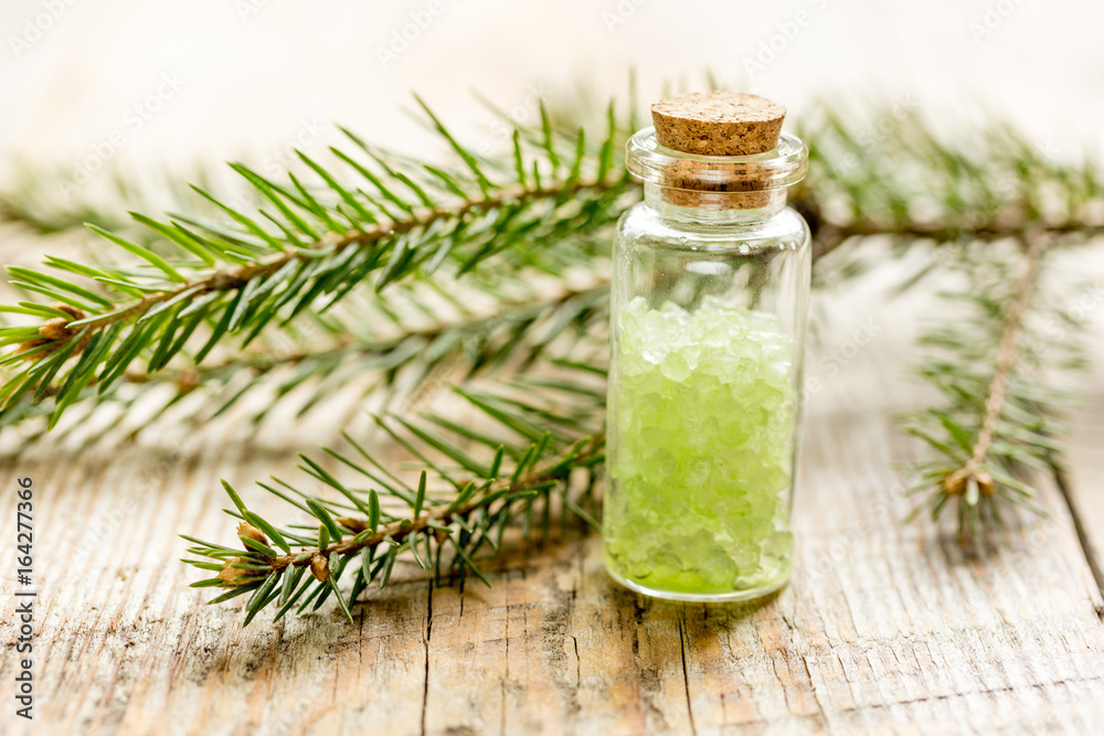 Spruce spa with organic salt in bottles on wooden table background