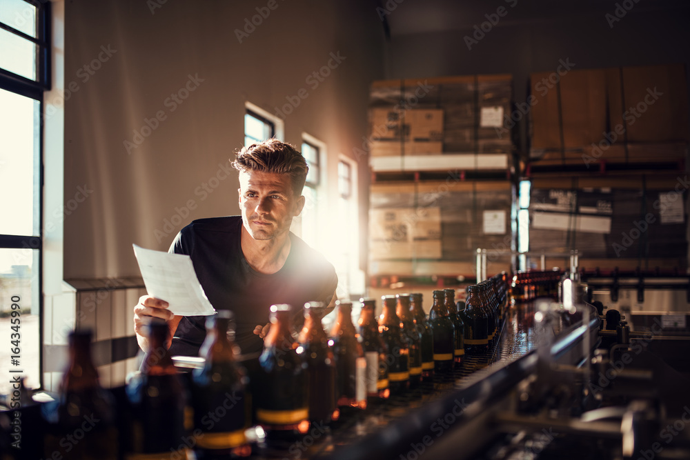 工人在啤酒厂生产线上检查流程
