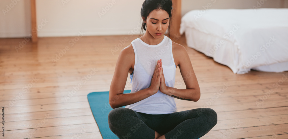 健身女性在家里以瑜伽姿势冥想
