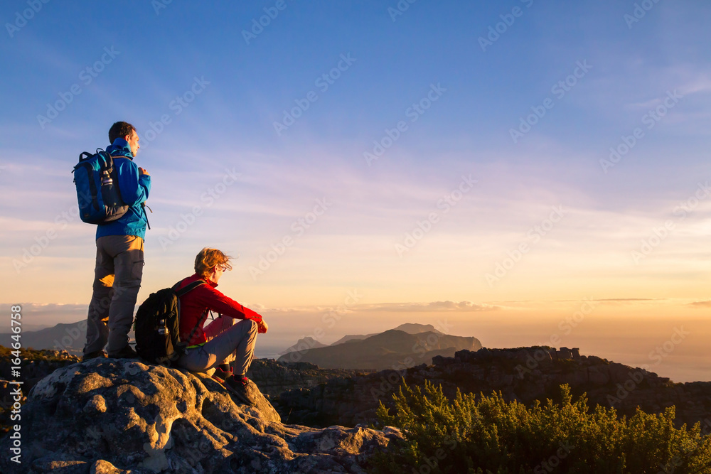 一对背着背包的徒步旅行者在山上、旅行和户外欣赏日落的全景
