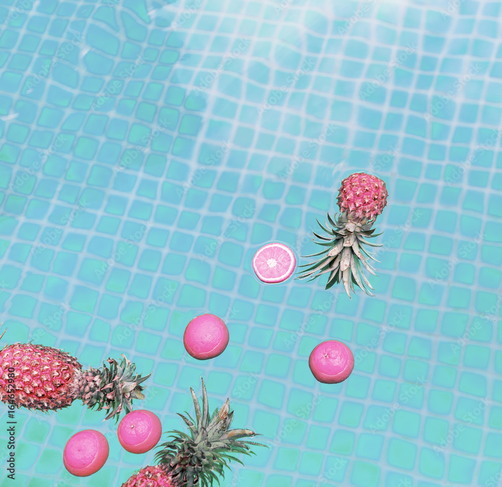 漂浮在游泳池中的菠萝和橙子鸟瞰图