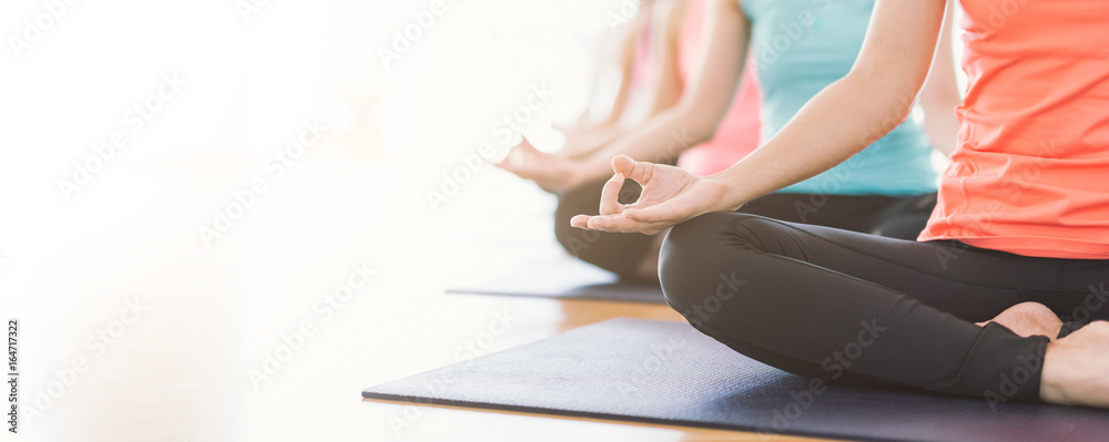 Attractive young Asian woman group exercising and sitting in yoga lotus position in yoga classes Bre