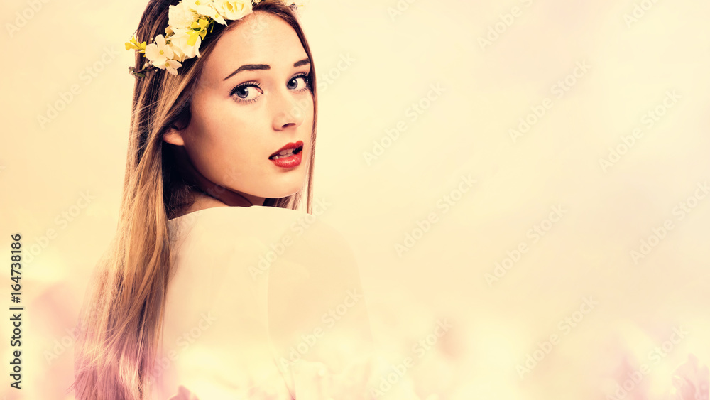 粉色花朵背景下的美丽年轻女子