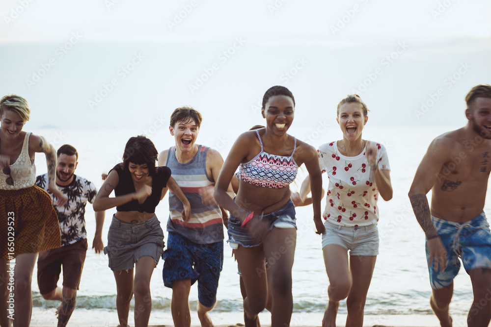 一群不同的朋友一起在海滩上跑步