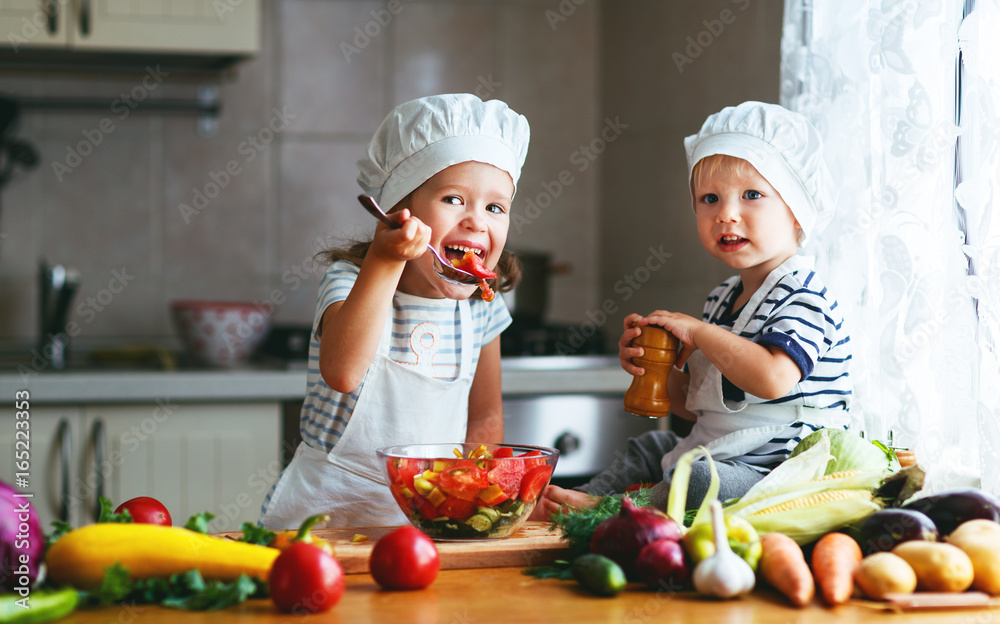 健康饮食。快乐的孩子们在厨房准备蔬菜沙拉。