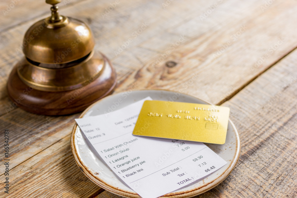 木桌背景上的餐厅账单、卡片和服务员戒指