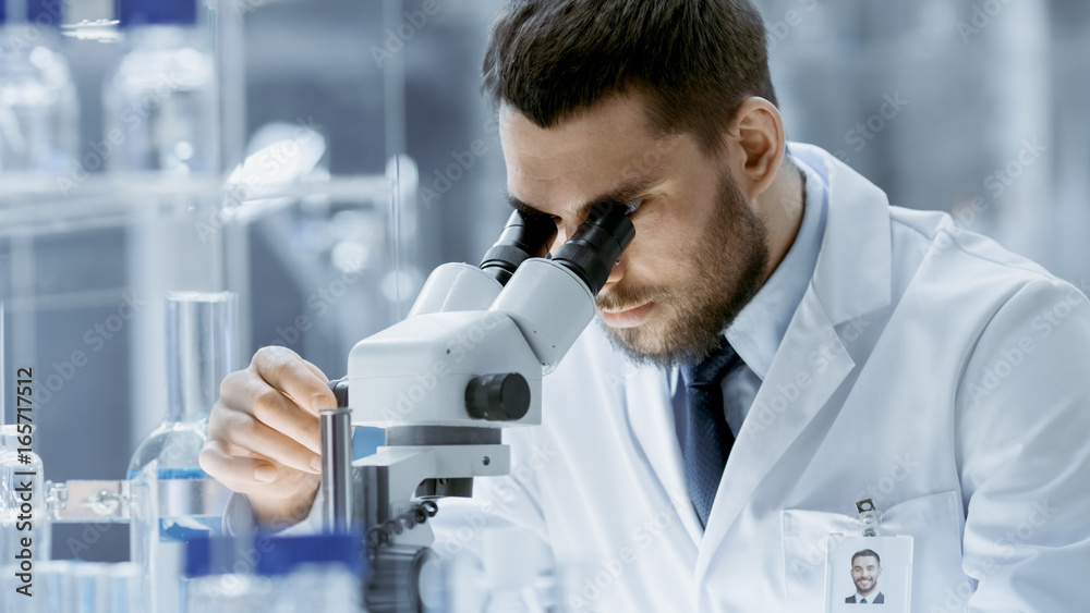 Close-up Shot of Research Scientist Adjusts His Microscope. Hes Working in a High-End Modern Labora