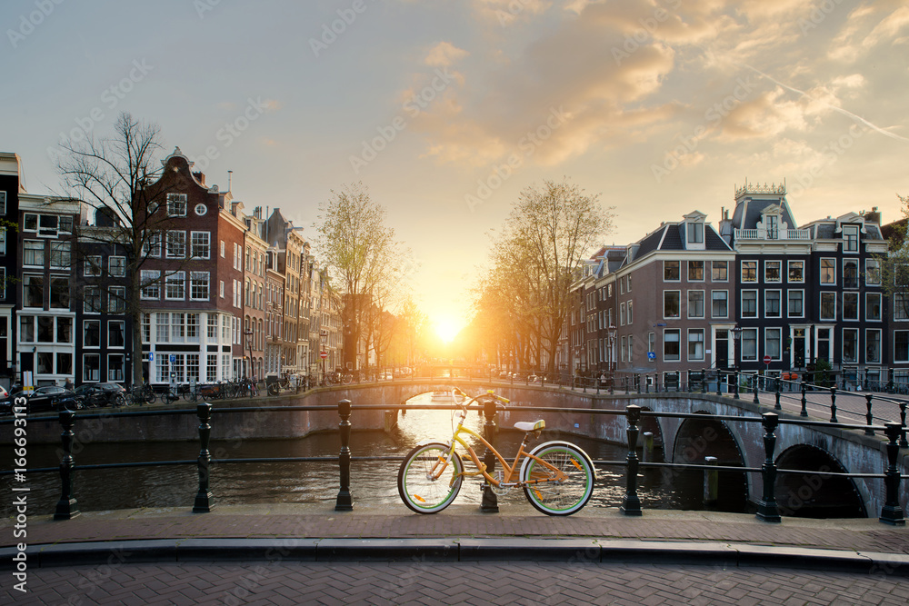 荷兰阿姆斯特丹运河上的一座桥上排列着自行车。自行车是交通工具的主要形式
