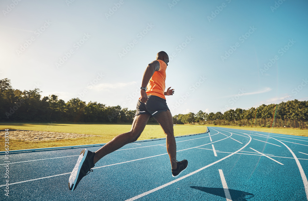 健康的运动员独自在外面的跑道上奔跑