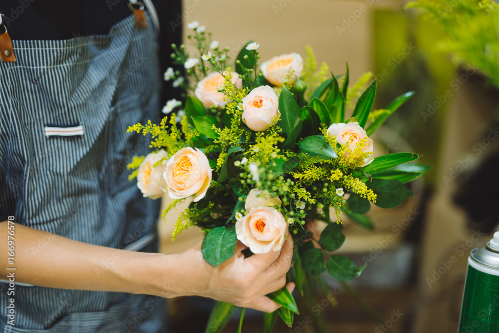 Male florist making beautiful bouquet at flower shop