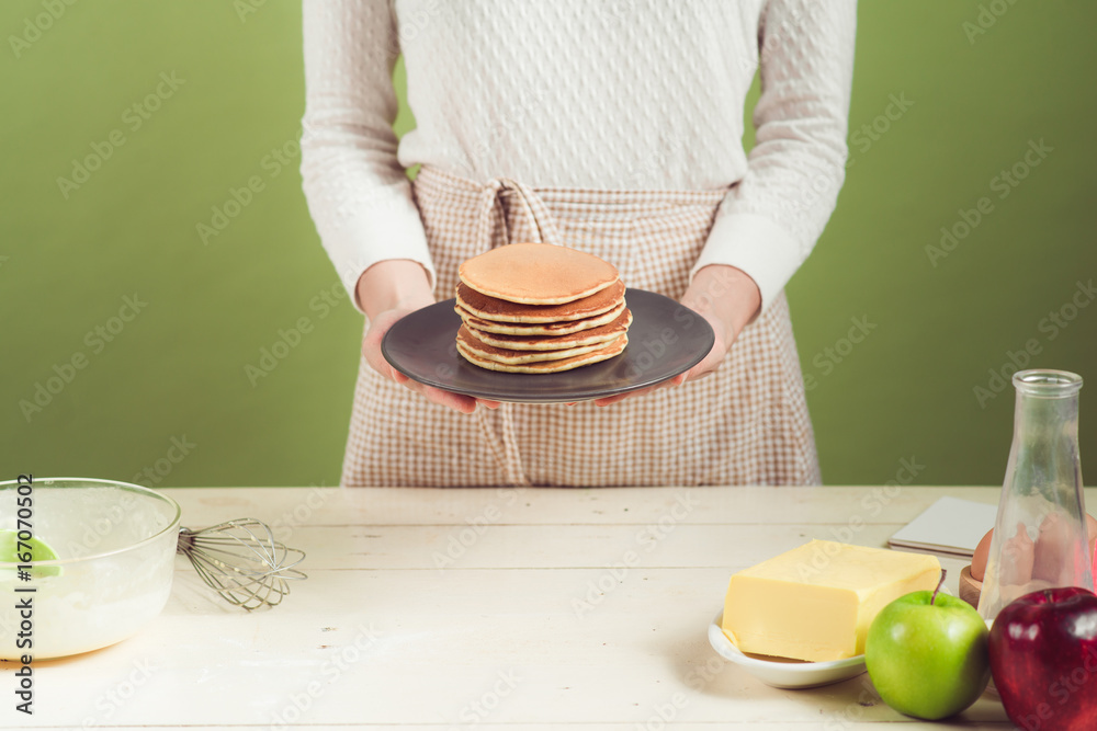 家里的妻子穿着围裙做。烹饪苹果蛋糕的步骤。切青苹果。