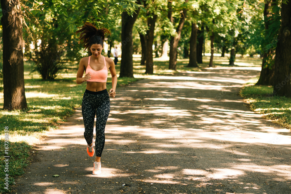 阳光明媚的一天，在公园户外跑步的健康女性