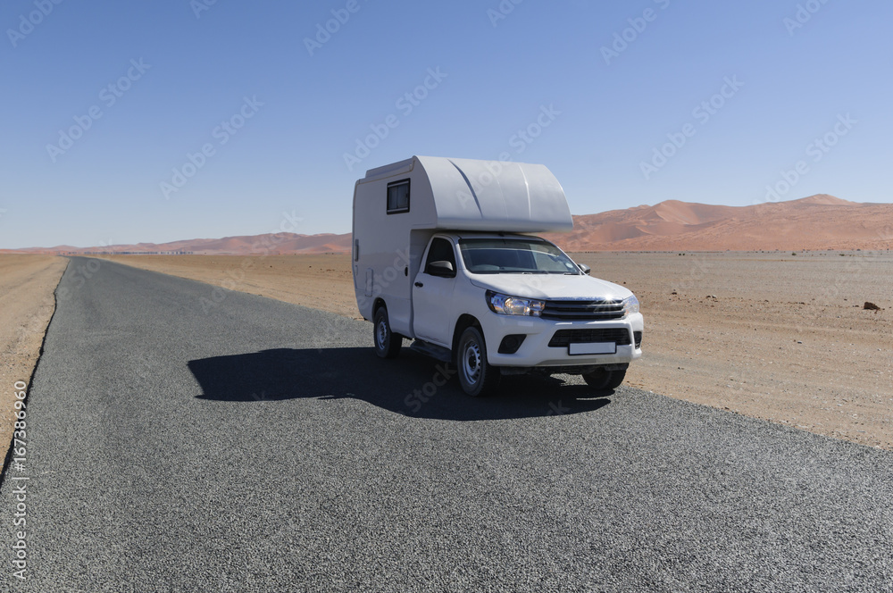 Motorhome in the desert / Traveling with the camper, on a road through the desert, Africa.