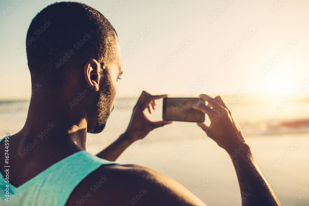 非洲男子在海滩上做手机摄影