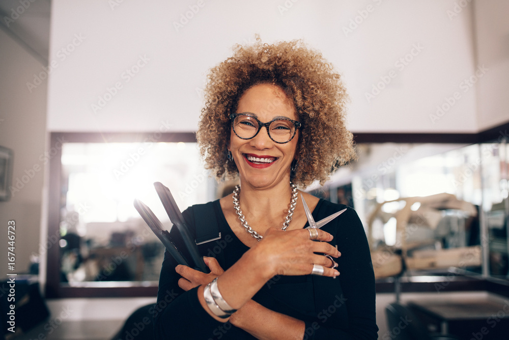 Female hairdresser at the salon holding hairdressing accessories