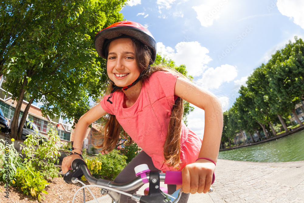 女孩骑着自行车沿着河堤前行