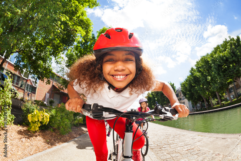 微笑的非洲女孩在夏天骑自行车
