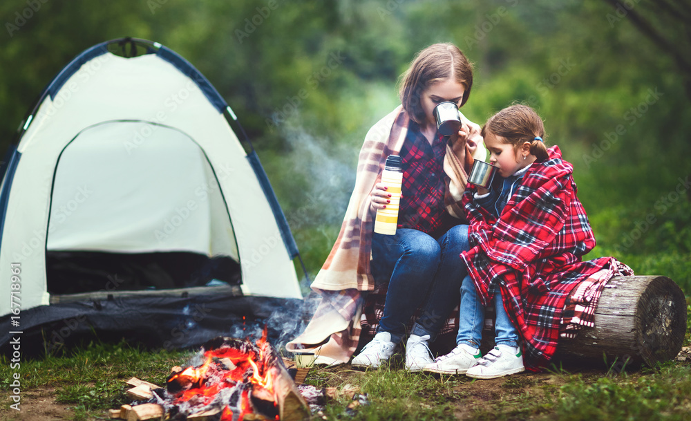 家庭母女带着帐篷在露营旅行中喝茶