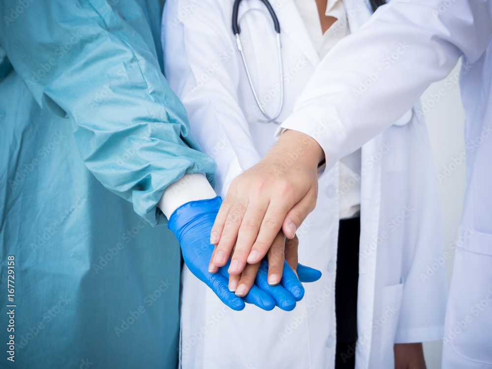 Team work doctors stacking hands for medical concept