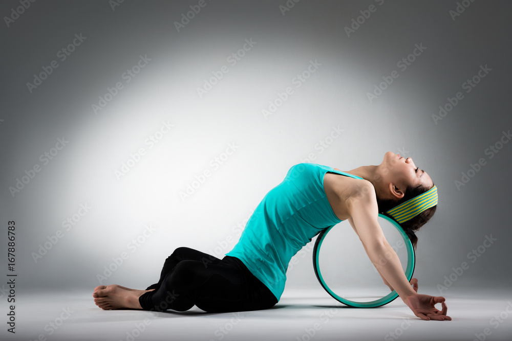 elegant female gym player lying on pilates ring