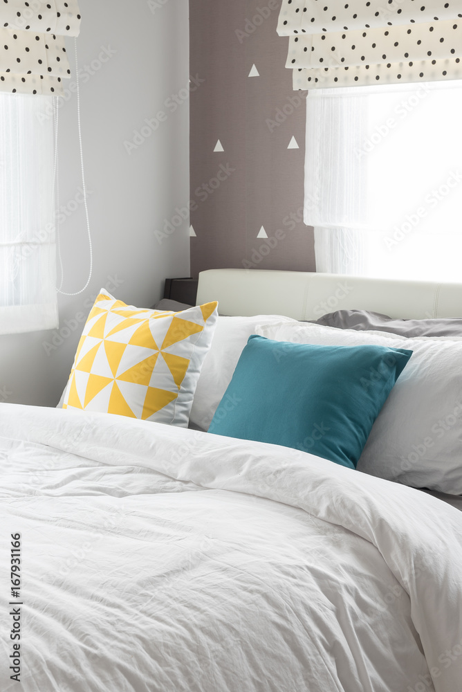 colorful pillows on white bed in modern bedroom