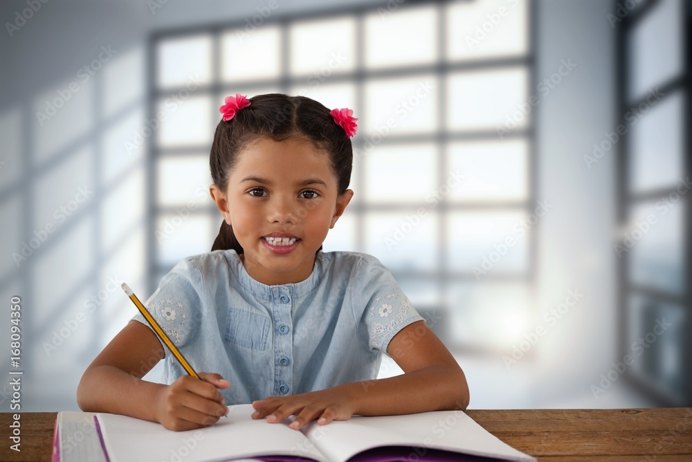 微笑的女孩在桌子旁的书中写字的合成图像