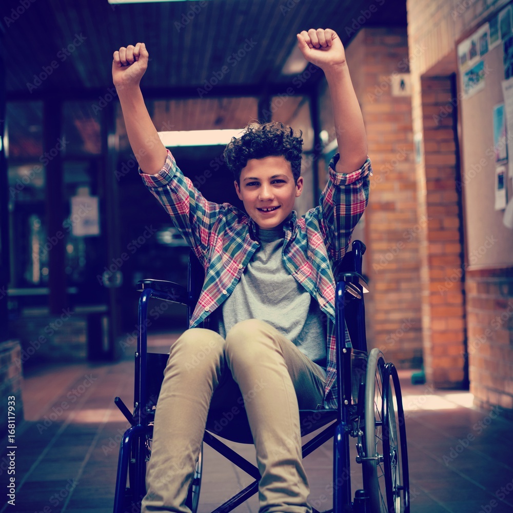 Disabled schoolboy on wheelchair in corridor at school