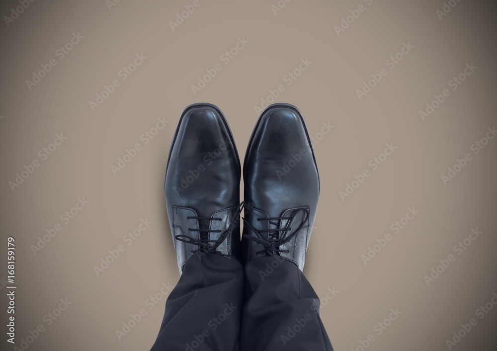 Black shoes on feet with brown background