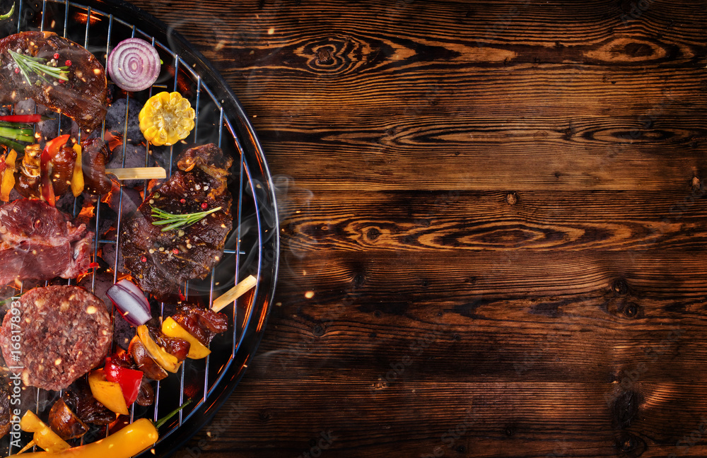 木板上烤架上鲜肉和蔬菜的俯视图