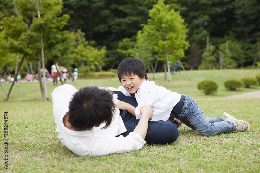 一个男孩和一个父亲在公园里玩