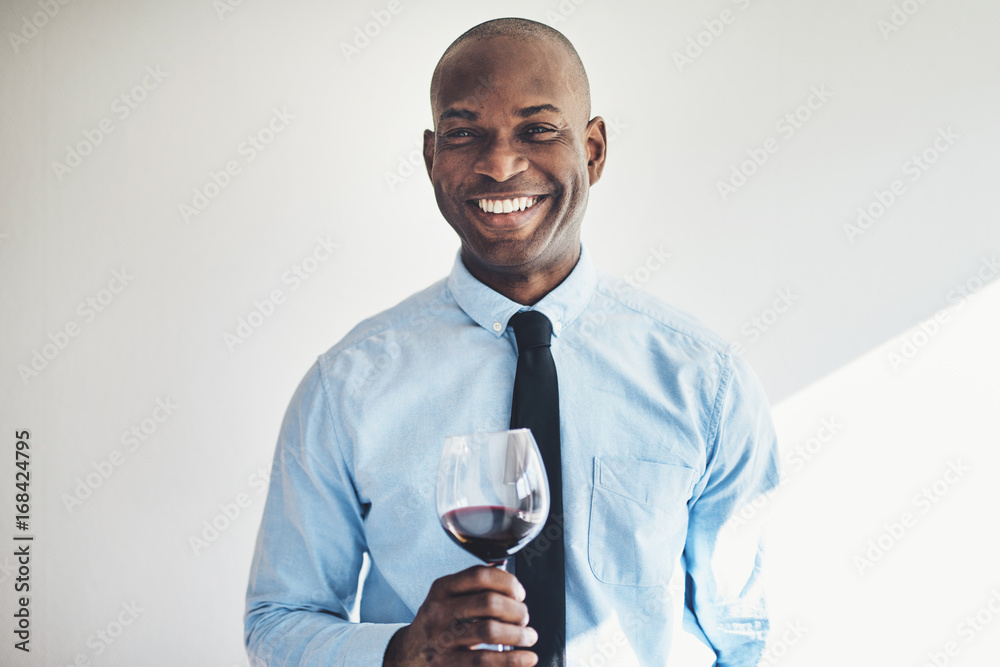 微笑的成熟男人喝着一杯红酒