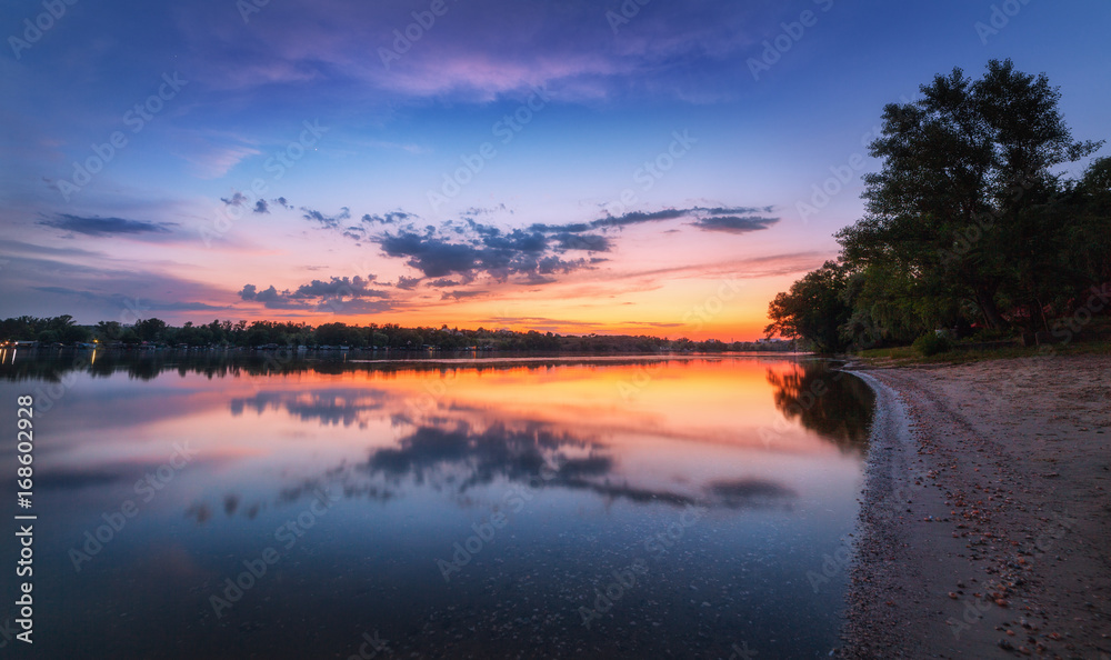 日落时，河流的宁静景象和云朵的多彩天空。湖泊的壮丽景观，蓝色
