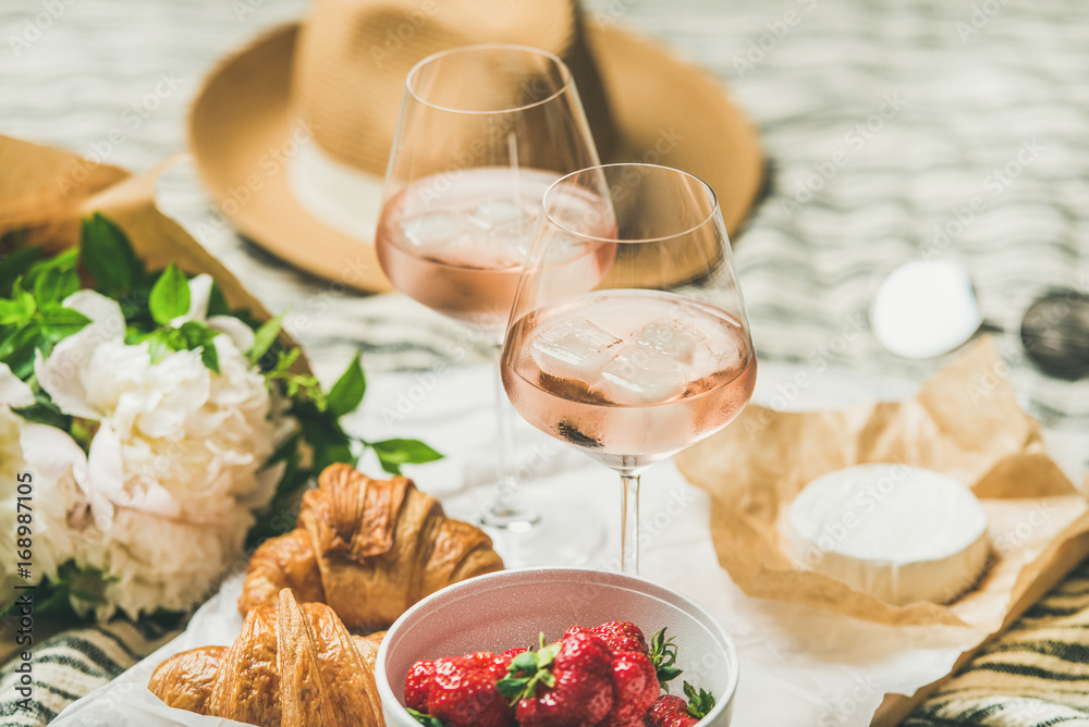 法式浪漫的夏季野餐环境。一杯加冰块的玫瑰酒，新鲜的草莓