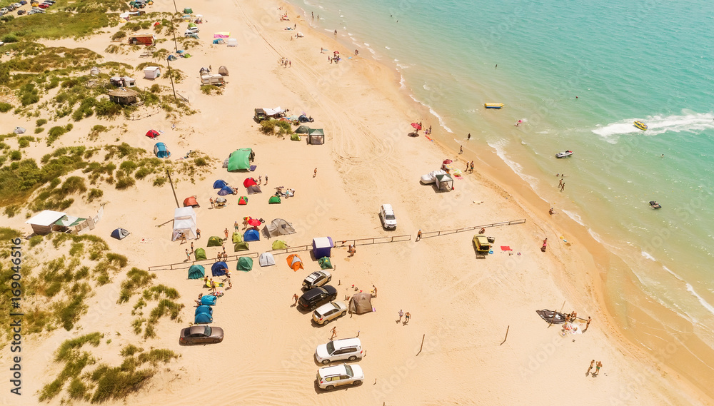 Drone aerial view of the camping on the sand beach with turquoise sea. Aerial view of the Sandy spit