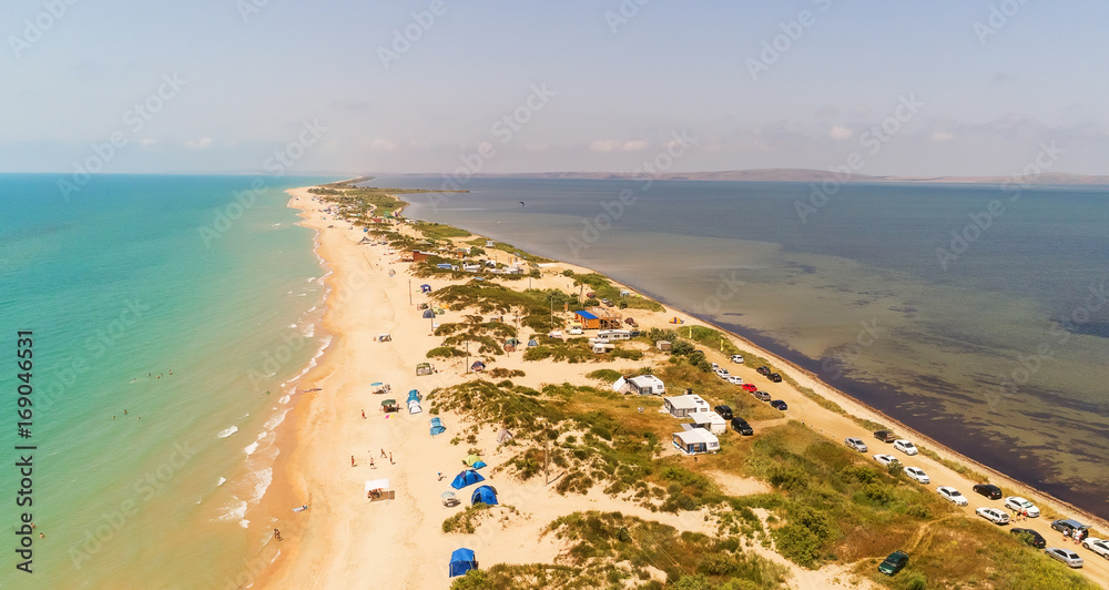 Drone aerial view of the long sand spit separates the sea with camping on the beach. Aerial view of 