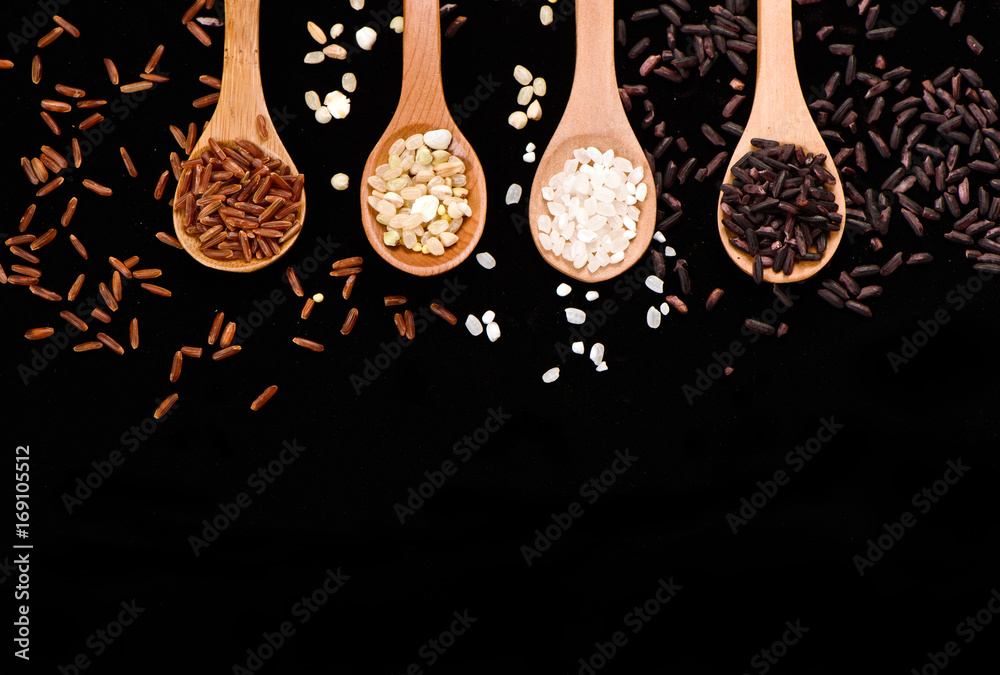 row of wood spoons with various rice：white rice,blck rice, red rice and grain rice