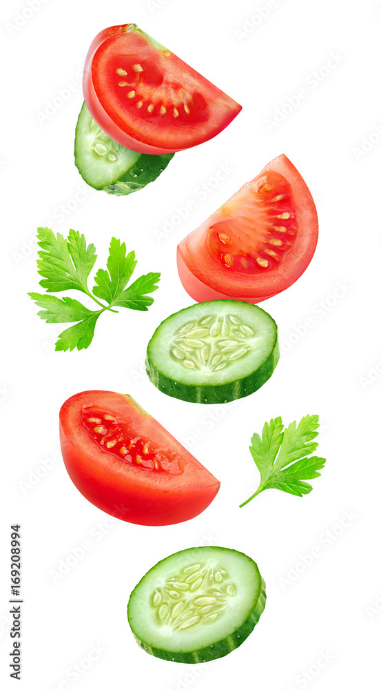 Isolated vegetables. Mixed slices of cucumber and tomato floating in the air isolated on white with 