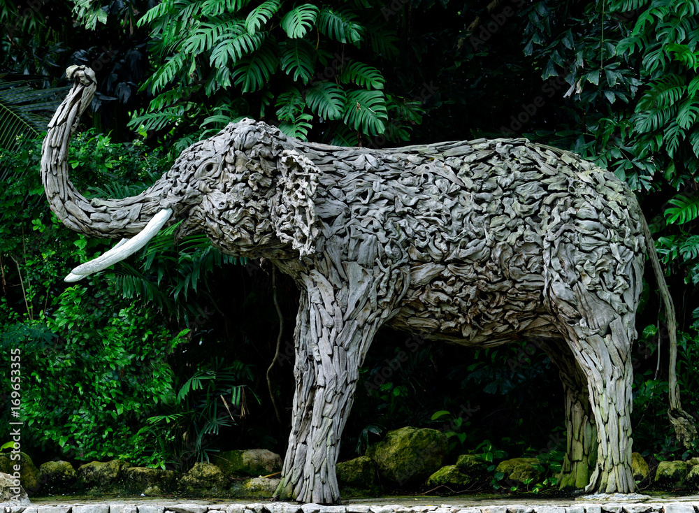 花园步行道上装饰的木制大象雕塑，手工制作的动物雕像