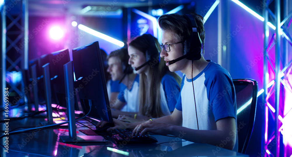 青少年玩家团队在电子竞技锦标赛上玩多人电脑视频游戏。队长发出Comma