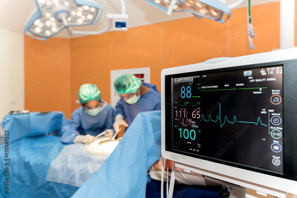 Medical monitor with doctor and an assistant in the operating room for surgical venous vascular surg