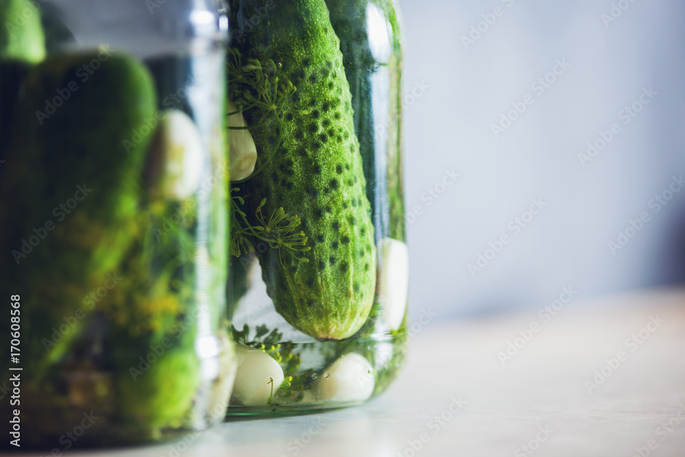 Pickled cucumbers in a jar with spices and herbs copy space