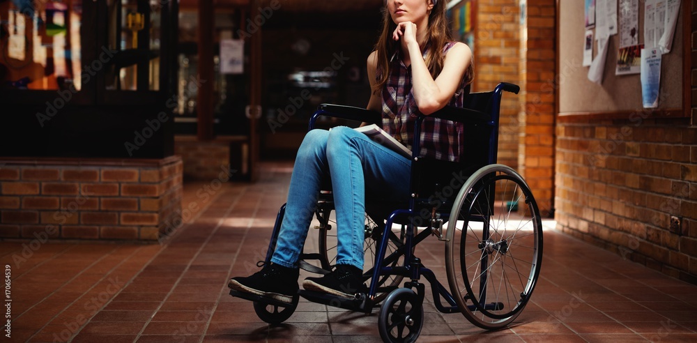 学校走廊上坐轮椅的残疾女学生