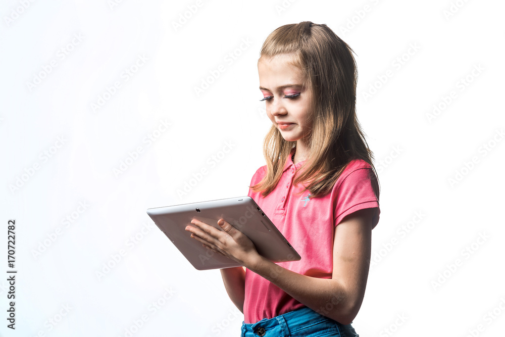 漂亮的小女孩，手里拿着一台平板电脑，背景是白色。孩子的表情。
