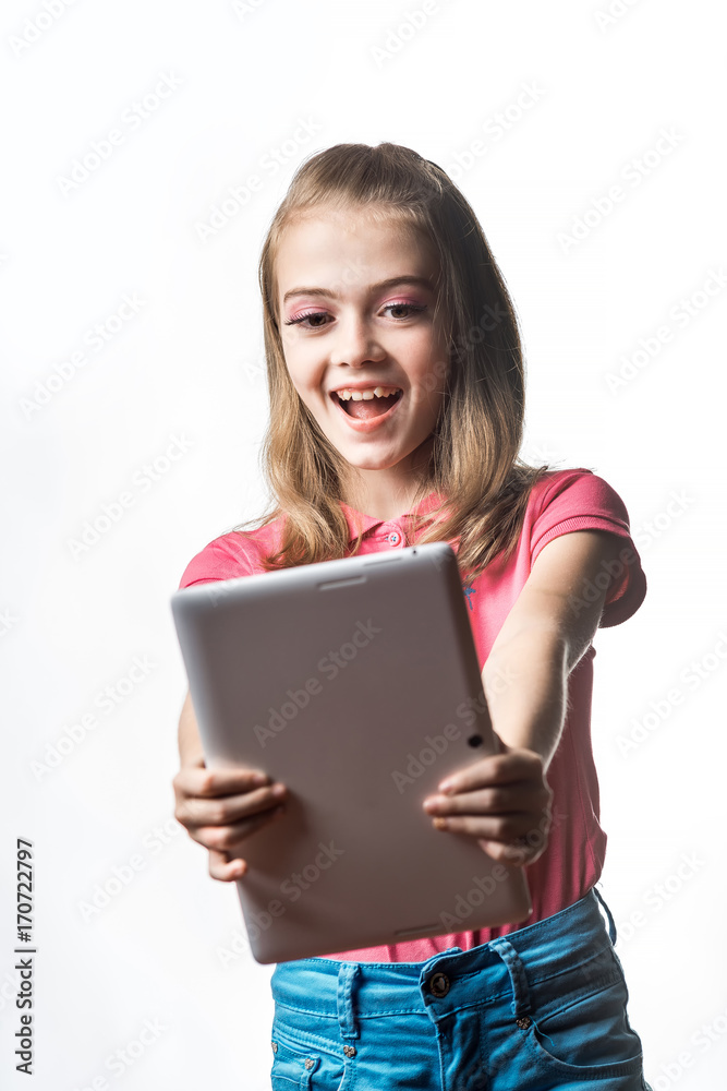 一个白色背景下拿着平板电脑的小女孩。孩子的情绪。