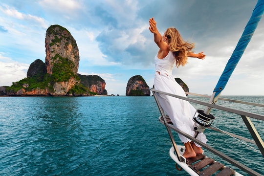 快乐的年轻女性肖像。快乐的女孩站在帆船甲板上，享受发现岛屿的乐趣