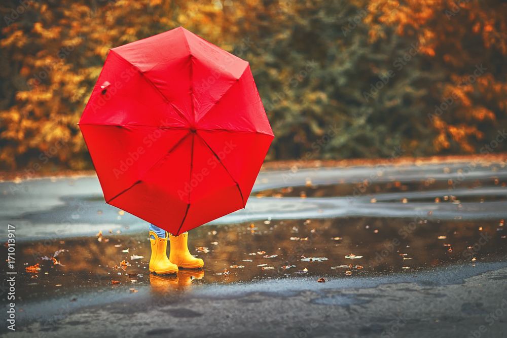 快乐的小女孩，在水坑里撑着雨伞和橡胶靴，秋天散步